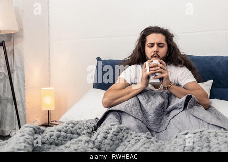 Nice handsome man blowing at the tea Stock Photo