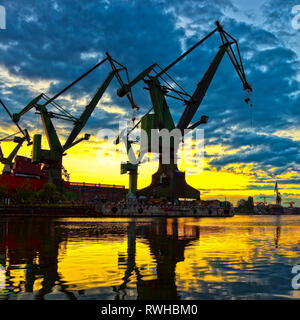 Big shipyard cranes at sunset in Gdansk, Poland. Stock Photo