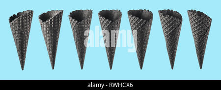 Various ice cream cones isolated on blue background. Various perspective of black waffle sugar cones on bright blue background Stock Photo
