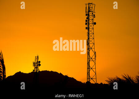 Silhouette of telecommunication antenna cellular tower for telephony with beautiful sunset sky background Stock Photo