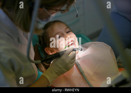 Little girl at dentist office, getting ready for a caries treatment. Prevention, pediatric medical care concept. Stock Photo