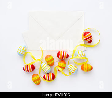 Festive background with easter eggs with ribbons and envelopes. Top view Stock Photo