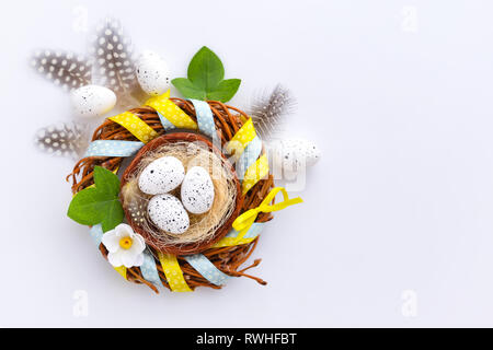 Easter eggs in the nest on a white background with empty space. Top view Stock Photo