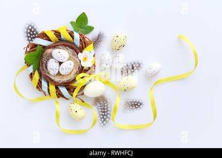 Easter eggs in the nest on a white background. Festive easter background. Top view Stock Photo