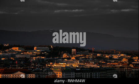 Panoramic cityscapes of Geneva in Switzerland.  Tthe rooftops of Geneva and the surrounding mountains at sunset as the sunlight reflect Stock Photo