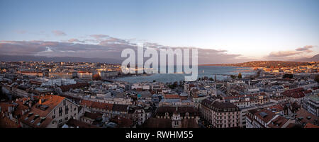 Panoramic cityscapes of Geneva in Switzerland.  Tthe rooftops of Geneva and the surrounding mountains at sunset as the sunlight reflect Stock Photo