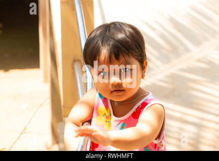 Cute, smiling, happy pre school age Vietnamese girl outside her home, Tan Chau, An Giang Province, Mekong Delta, Vietnam Stock Photo