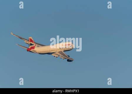 British Airways Boeing 747 Jumbo Jet jet plane airliner G-BNLY taking off from London Heathrow Airport, UK, in blue sky at dusk glow Stock Photo