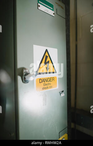 Close up shot of an electrical enclosure box with a warning sign. Stock Photo