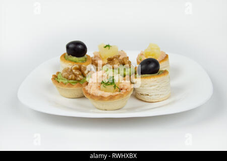 Several beautiful tartlets with different fillings on a white background Stock Photo