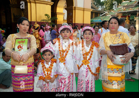 Proud Burmese family with their brightly costumed heavily makeup boys attending their coming of age ceremony in Mandalay Myanmar Stock Photo
