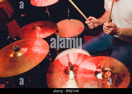 music, people, musical instruments and entertainment concept - male musician or drummer playing drum kit at studio over holidays lights background Stock Photo
