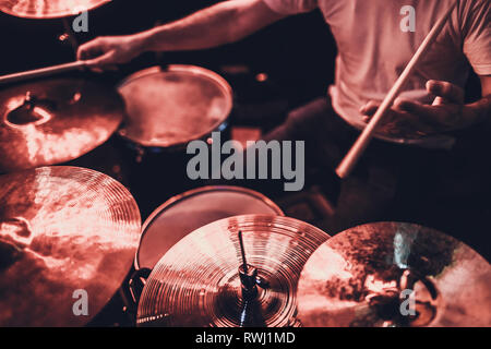 music, people, musical instruments and entertainment concept - male musician or drummer playing drum kit at studio over holidays lights background Stock Photo