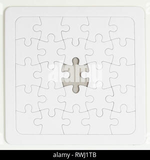 A puzzle is missing piece to complete. white pieces and green space to add  text Stock Photo - Alamy