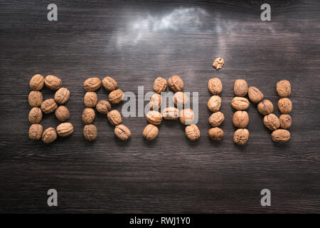 Brain letters sign made with walnuts against wood background. Storm lights. Brainstorming concept. Brain health concept nutrition Stock Photo