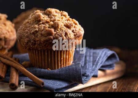 Closeup of a cinnamon muffin and sticks on a blue napkin on a dark background Stock Photo