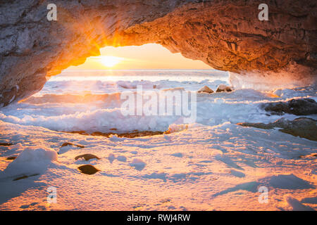 Sunset through the Arches a limestone rock formation on the shores of Newfoundland and Labrador Stock Photo