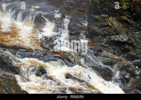 PLODDA FALLS TOMICH HIGHLAND SCOTLAND ROCKS AND PEAT STAINED WATER AT THE FOOT OF THE FALLS Stock Photo