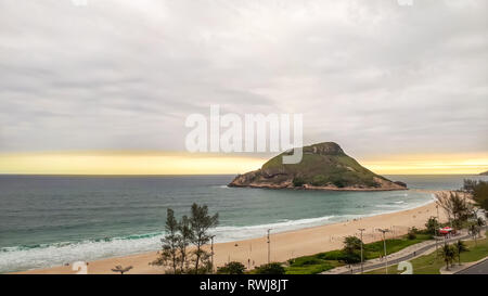 Rio de Janeiro / RJ / Brazil - 12/06/2018: A top view of the Pontal beach in Rio de Janeiro, during a yellowish sunset and a cloudy sky with distant s Stock Photo