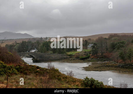County Donegal, Ireland. 06 March 2019. Ireland weather - after heavy overnight rain, it was a day of strong winds and driving rain across County Donegal.  Overcast and grey at the bridge where the River Lackagh flows into Sheephaven Bay. Credit: David Hunter/Alamy Live News. Stock Photo
