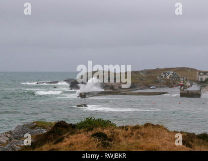 County Donegal, Ireland. 06 March 2019. Ireland weather - after heavy overnight rain, it was a day of strong winds and driving rain across County Donegal. Waves crashing over the harbour wall at Portnablagh. Credit: David Hunter/Alamy Live News. Stock Photo