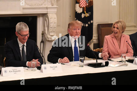 First Daughter and Advisor to the President Ivanka Trump (R) reacts as United States President Donald J. Trump holds her hand and Apple CEO Tim Cook attends the American Workforce Policy Advisory Board meeting, at the White House, Washington, DC, March 6, 2019. The board consists of 25 members outside government, representing leading companies, academics and elected leaders. Credit: Mike Theiler/CNP | usage worldwide Stock Photo