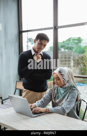 the owner give a briefing to a new employee about operate the computer  Stock Photo