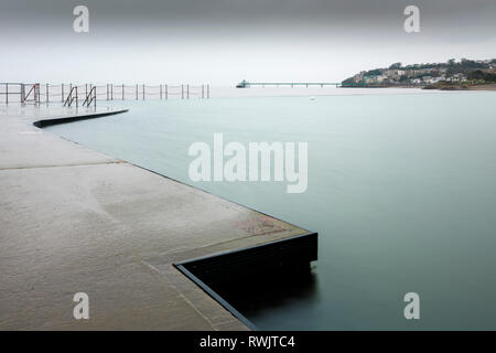 The Marine Lake at Clevedon with the Victorian pier in the Severn Estuary beyond. North Somerset, England. Stock Photo