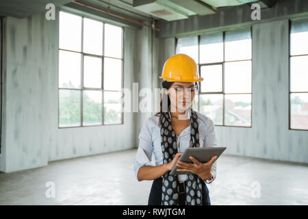 woman engineer wearing hardhat hold a digital tablet Stock Photo