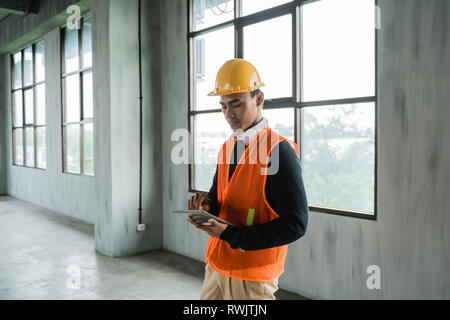 man engineer hold tablet wearing hardhat and veils Stock Photo