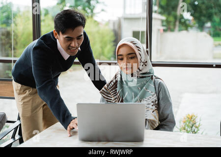 the owner give a briefing to a new employee about operate the computer  Stock Photo
