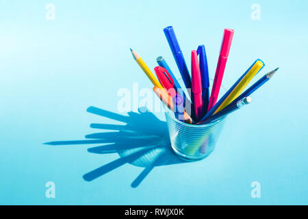Colorful pen and pencil in glass with long shadow on pastel background.business creativity concept ideas Stock Photo