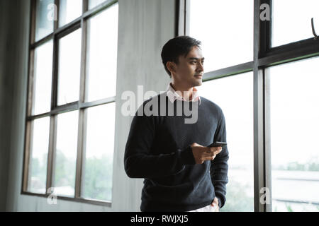 Confident young businessman using cell phone Stock Photo