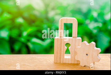 Wooden padlock and gear. Conceptual strength and security mechanisms and critical nodes. Protection against unauthorized access, insurance and securit Stock Photo