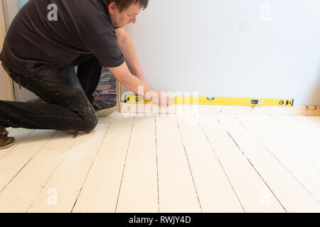 man checking floor level using spirit level Stock Photo