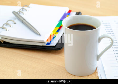 office desk table with cup of coffee and  planning agenda for input the text and newspapers Stock Photo