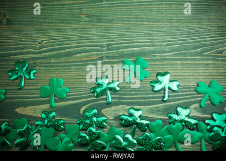 Glittery shamrocks on a wooden green background with space Stock Photo