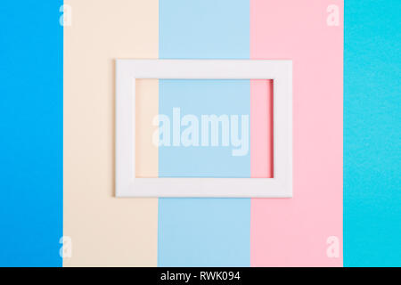 Abstract pastel colorful paper background with white wooden frame, flat lay with copy space