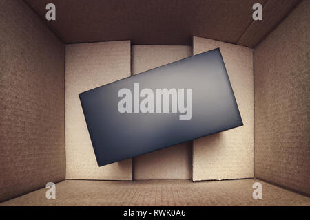 Black mystery box into rough cardboard box top view Stock Photo