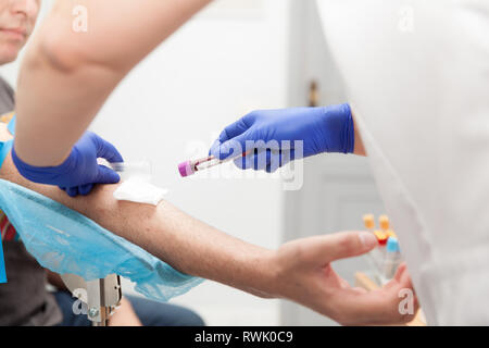 laboratory practitioner extracting blood from a patient Stock Photo