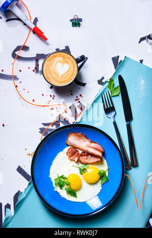 Fried eggs with bacon, english breakfast. Cup of coffee cappuccino. Top view, copy space. Stock Photo
