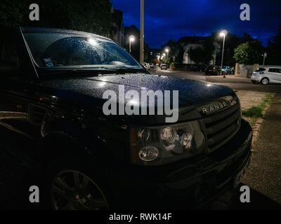 Strasbourg, France - Sep 19, 2017: Front fiew of parked Land Rover big SUV covered with thiny rain water drops at night Stock Photo