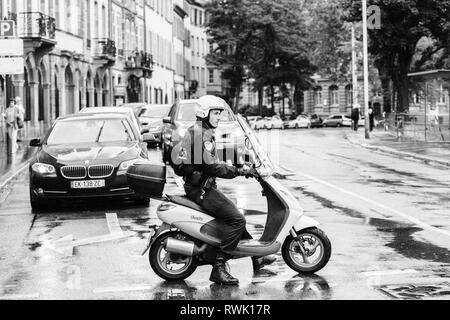 Strasbourg, France - Sep 12, 2017: Young French police officer blocking street on a rainy day during protest - black and white Stock Photo