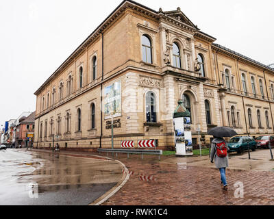 Karlsruhe, Germany - Oct 29, 2017: German city of Karlsruhe with young woman with umbrella walking toward Staatliche Kunsthalle Karlsruhe State Art Gallery Stock Photo