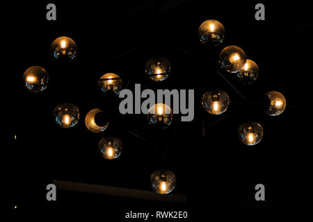 Close up many yellow lamps in cafe, bar at night. round lamps isolated on black background. bokeh Stock Photo