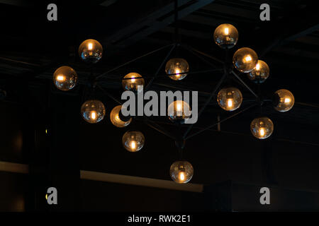 Close up many yellow lamps in cafe, bar at night. round lamps isolated on black background. bokeh Stock Photo