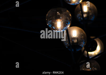 Close up many yellow lamps in cafe, bar at night. round lamps isolated on black background. bokeh Stock Photo