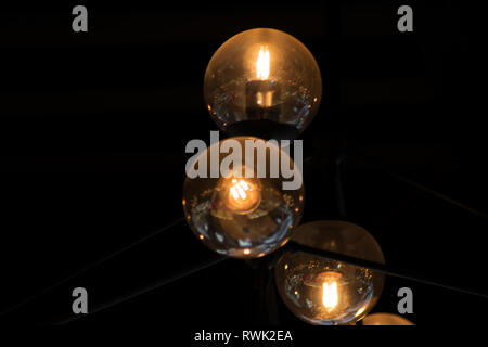Close up many yellow lamps in cafe, bar at night. round lamps isolated on black background. bokeh Stock Photo