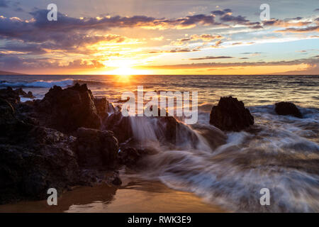 Soft water over lava rocks during sunset; Makena, Maui, Hawaii, United States of America Stock Photo