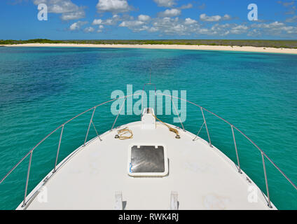 The front of a yacht cruising in the Galapagos islands national park with the beach of South Plaza Island in the background, Pacific Ocean, Ecuador. Stock Photo